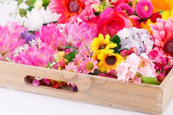 Colorful fabric flowers in wooden box.