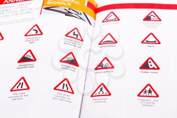 Traffic rules study book opened page with road signs.