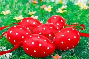 Easter red spotted eggs on artificial grass background.
