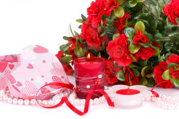 Red flowers, candles and gift box close up picture.