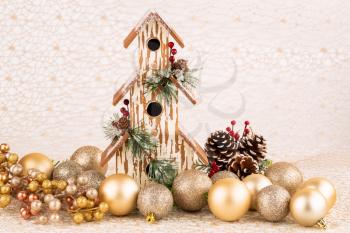 Christmas decoration with birdhouse, cones and balls on the golden net.
