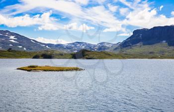 Landscape with mountains, lake, sky and clouds in Norway.