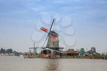 Traditional, authentic dutch windmills at the river Zaam in Zaanse Schans village.
