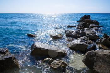 Blue Mediterranean sea with the sparkling surface and stones in Cyprus.