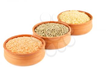 Colorful lentils in the ceramic bowls isolated on white background.