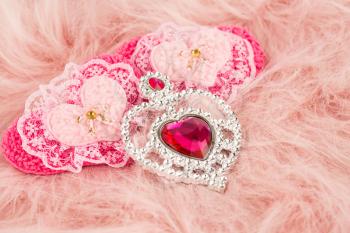 Jewelry and fabric hearts with stones on pink fur background.