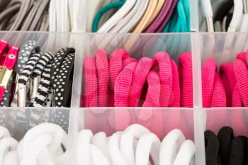 The assortment of colorful elastic hair bands in plastic box.