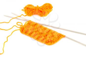 Yellow yarn with knitting needles on white background.