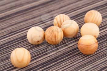 Wooden balls on striped fabric background.