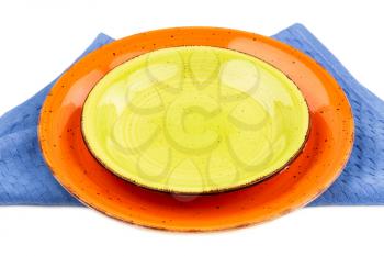 Two colorful empty plates on blue cotton towel.