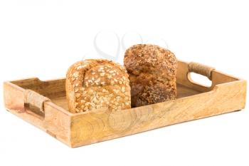Wholegrain bread buns with seeds and oat on wooden tray isolated on white background.