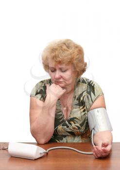 Senior lady measures arterial pressure , use digital tonometer . Isolated. Upset by instrument readings.
