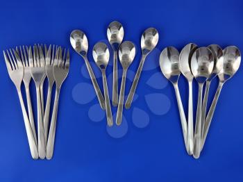 Table serving-knife,plate,fork and   on  blue background.