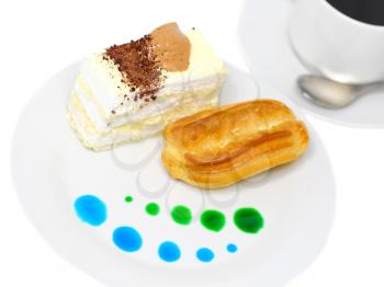 Sponge cakes and eclair cake on plate with fruit juice spots. Isolated