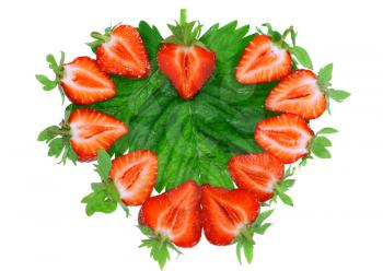 A fresh strawberries in heart shape on green foliage . Isolated
