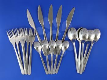 Table serving-knife,plate,fork and   on  blue background.