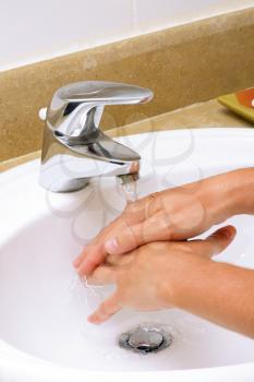 Washing hands before eating in white sink.