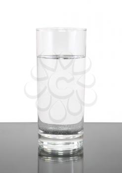 Glass of clean water on white- gray background. Isolated