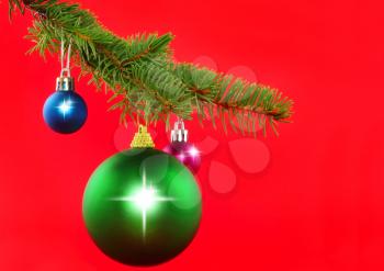 Christmas decoration-colour balls on fir branches on red background .