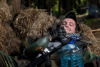 Paintball player resting and smoking a cigar