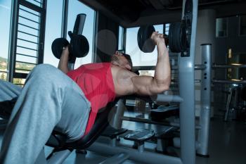 Bodybuilder Exercise With Hand Weights On Bench