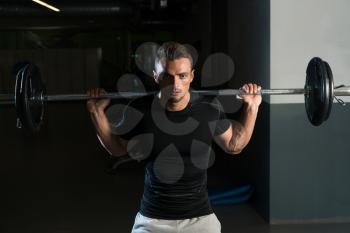 Young Man In Black T-Shirt Doing Barbell Squat