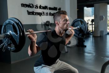 Fitness Trainer Doing Squats With Barbells