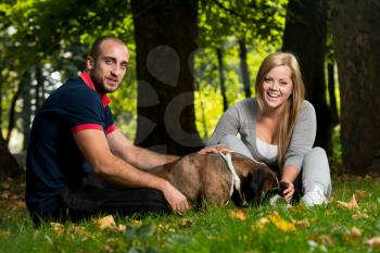 Young People With Their Dog In The Park