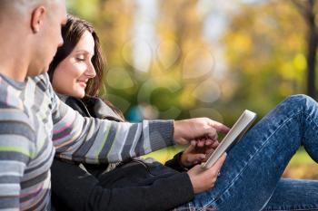 Couple Using Tablet Pc In Park