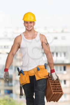 Worker With Protective Gear Wearing A Big Brick