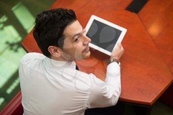 Portrait Of A Young Business Man Using A Touchpad In The Office