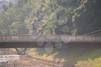 Young Woman Running On Bridge In Wooded Forest Area - Training And Exercising For Trail Run Marathon Endurance - Fitness Healthy Lifestyle Concept