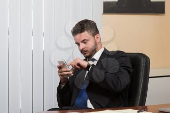 Young Businessman Working In His Office While Talking On The Phone