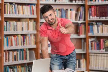 Portrait Of A Young Clever Student Showing Thumbs Up In College Library - Shallow Depth Of Field