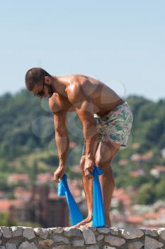 Sportsman Exercising With A Resistance Band Outdoors
