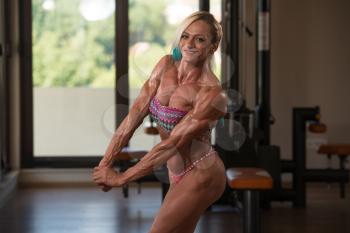 Portrait Of A Middle Aged Woman Posing Bodybuilding Poses In Modern Fitness Center