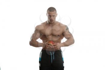 Portrait Of Young Bodybuilder Holding Apple In His Hand - Isolated On White Background