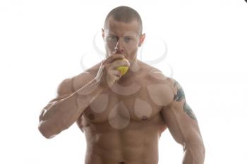 Portrait Of Young Bodybuilder Eating A Apple - Isolated On White Background