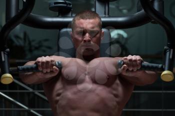 Bodybuilder Doing Heavy Weight Exercise For Chest On Machine