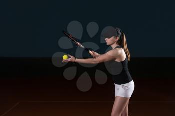 Portrait Of Female Tennis Player With Racket Ready To Serves Toss Ball