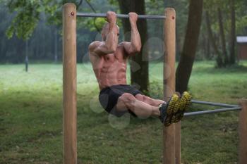 Young Athlete Working Out Biceps In An Outdoor Gym - Doing Street Workout Exercises
