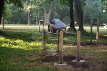 Athlete Working Out Hand Stand On Parallel Bars In An Outdoor Gym - Doing Street Workout Exercises