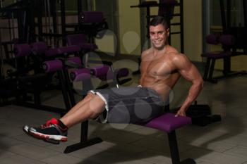 Young Healthy Man Exercising Abdominals On Bench
