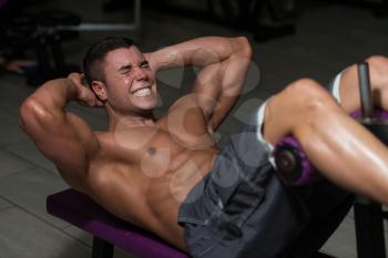 Young Healthy Man Exercising Abdominals In Gym