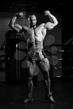 Man Standing Strong In The Gym And Flexing Muscles - Muscular Athletic Bodybuilder Fitness Model Posing After Exercises
