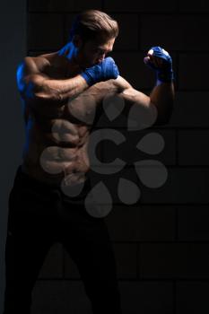 Handsome Man In Blue Boxing Gloves - Boxing In Gym - The Concept Of A Healthy Lifestyle - The Idea For The Film About Boxing