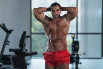 Portrait Of A Young Physically Fit Hispanic Man Showing His Well Trained Abdominal Muscles - Muscular Athletic Bodybuilder Fitness Model Posing After Exercises