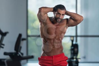 Portrait Of A Young Physically Fit Hispanic Man Showing His Well Trained Abdominal Muscles - Muscular Athletic Bodybuilder Fitness Model Posing After Exercises