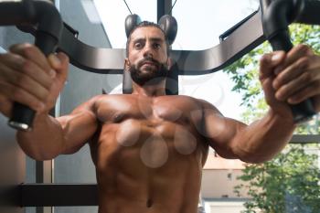 Strong Latin Man In The Gym And Exercising Chest On Machine - Muscular Athletic Bodybuilder Fitness Model Exercise