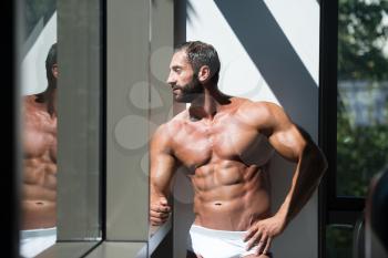 Portrait Of A Sexy Muscular Man In Underwear Looking Through Window